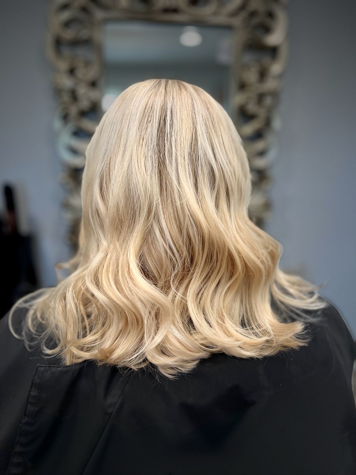 Creamy blonde lob styled with soft beach waves