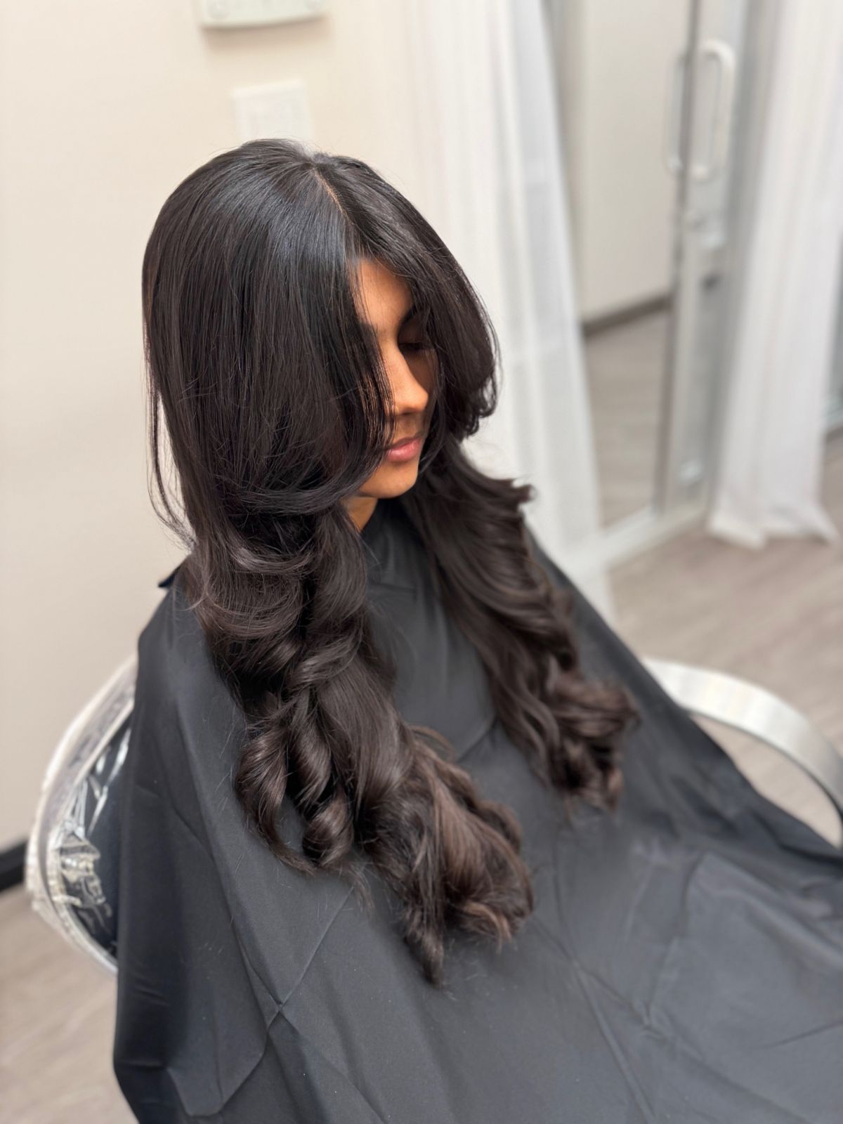 Dark hair styled with voluminous curls and layers